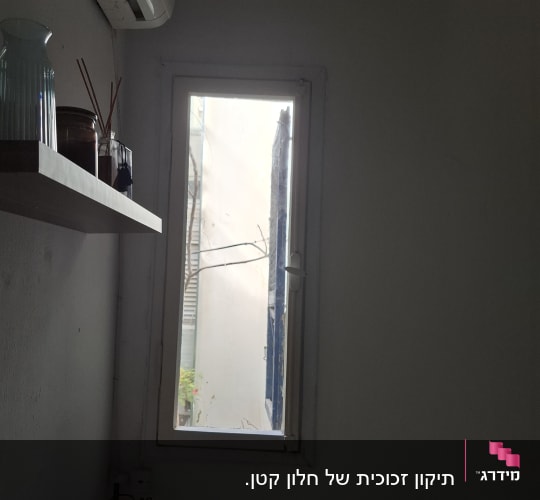 חלון זכוכית צר עם מסגרת לבנה בחדר מגורים